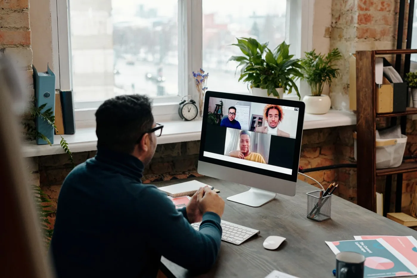 Un commercial prend des notes pendant une visioconférence avec ses interlocuteurs.